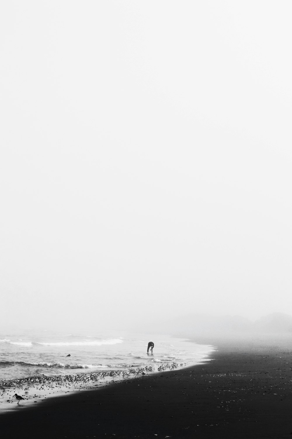 grayscale photo of man on seashore