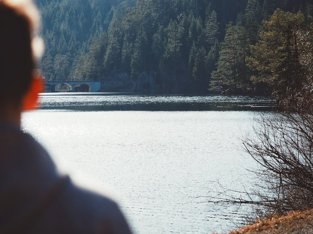 man wearing gray top looking at lake