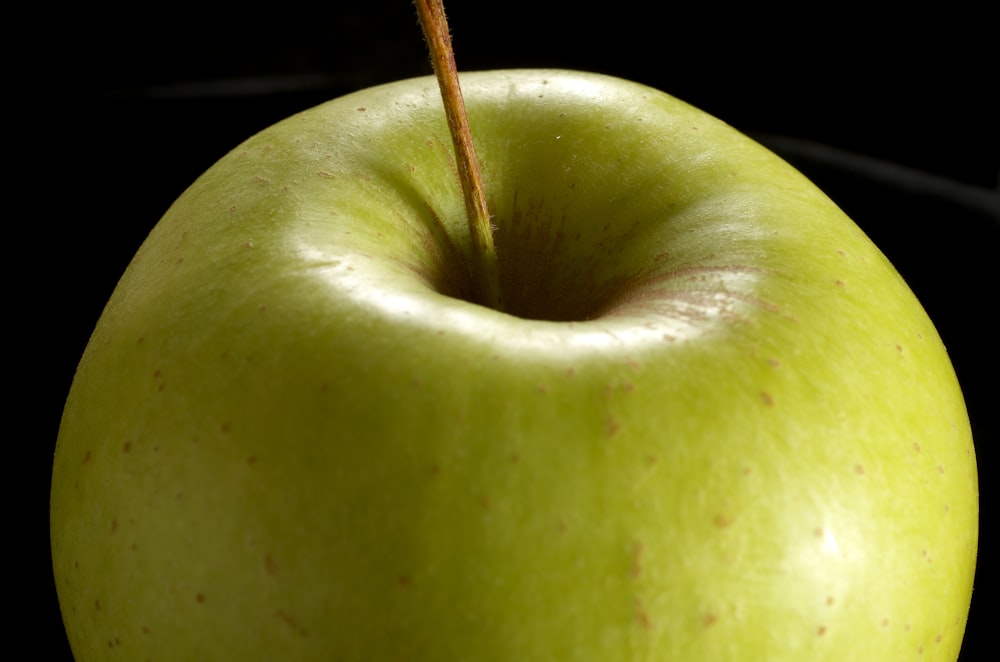 close view of green apple on black background