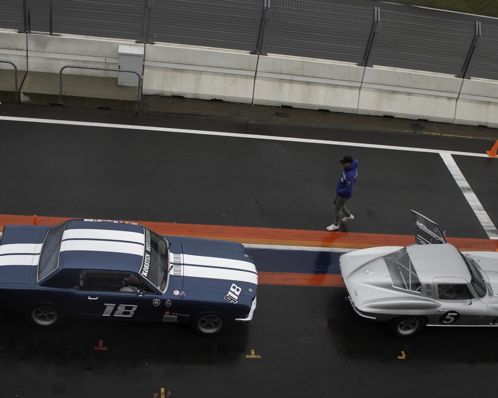 person beside blue race car