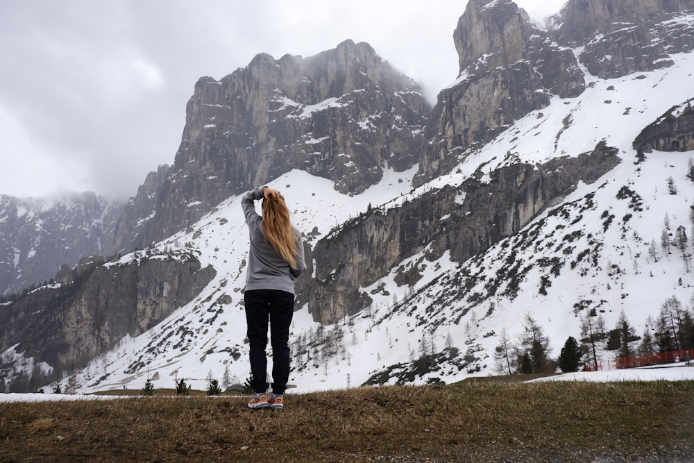 femme debout face aux montagnes pendant la journée