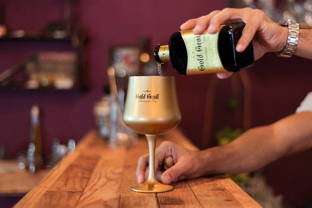 person pouring wine to wine glass