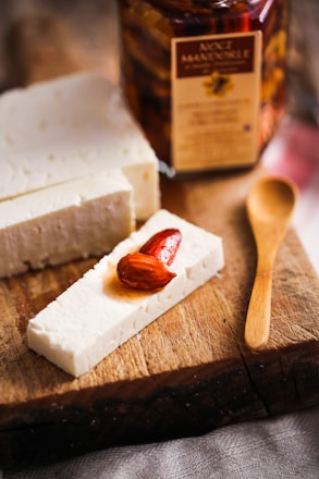 A bright photo of lactose-free dairy alternatives like almond milk and cheese on a wooden board.