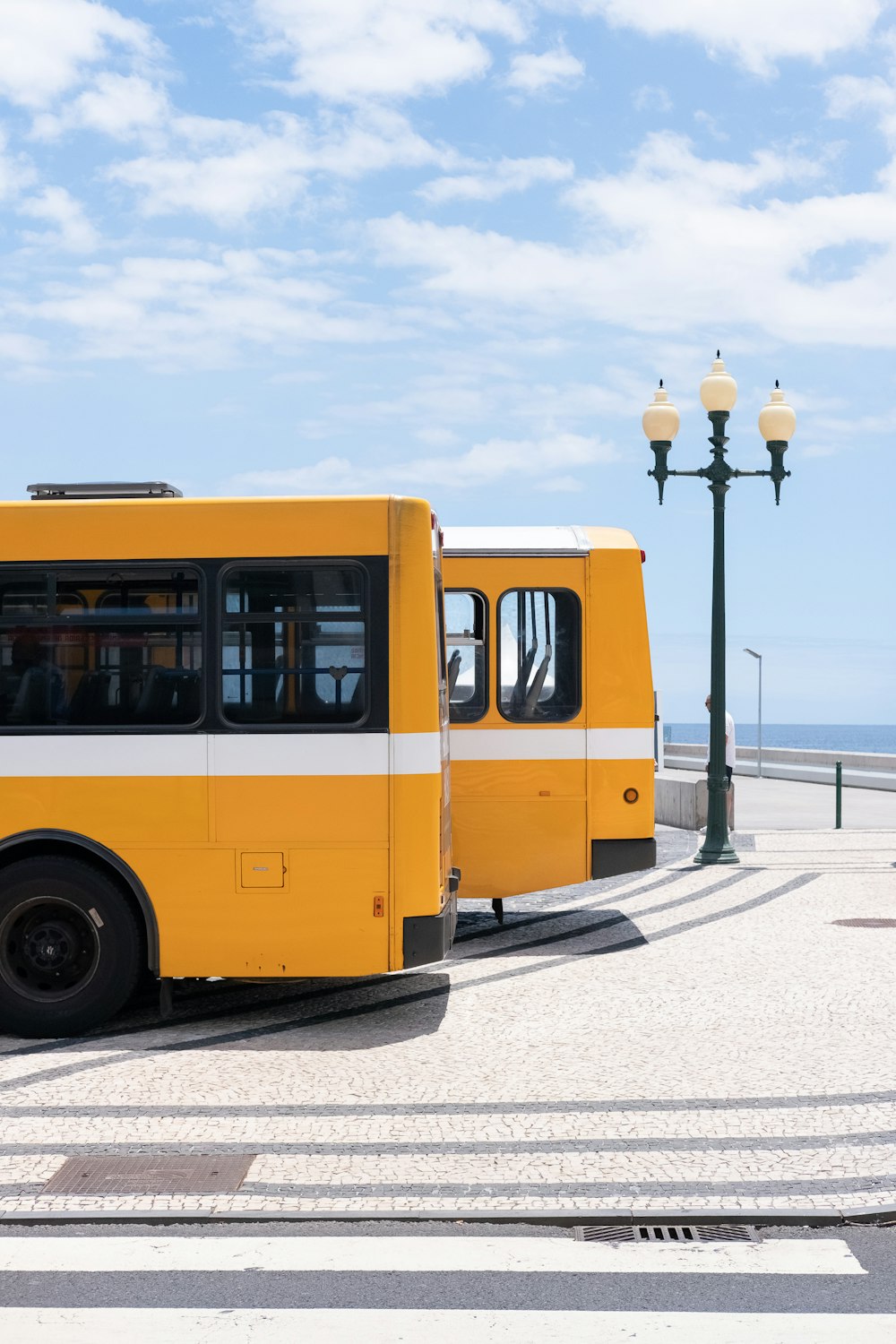 昼間の黄色いバス2台