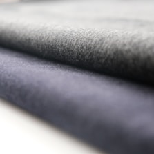 A close-up view of rolled fabric with a soft texture. The fabric appears to have a smooth finish, and the folds suggest it is thick and durable.