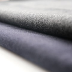 A close-up view of rolled fabric with a soft texture. The fabric appears to have a smooth finish, and the folds suggest it is thick and durable.