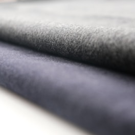A close-up view of rolled fabric with a soft texture. The fabric appears to have a smooth finish, and the folds suggest it is thick and durable.