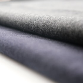 A close-up view of rolled fabric with a soft texture. The fabric appears to have a smooth finish, and the folds suggest it is thick and durable.