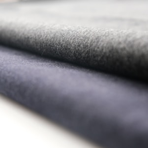 A close-up view of rolled fabric with a soft texture. The fabric appears to have a smooth finish, and the folds suggest it is thick and durable.