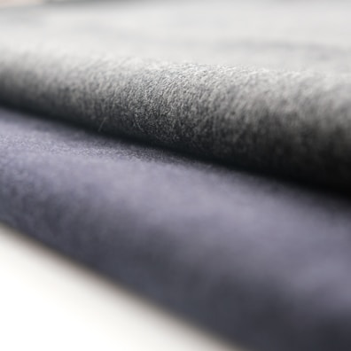 A close-up view of rolled fabric with a soft texture. The fabric appears to have a smooth finish, and the folds suggest it is thick and durable.