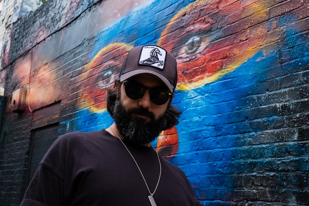 man standing beside graffiti wall