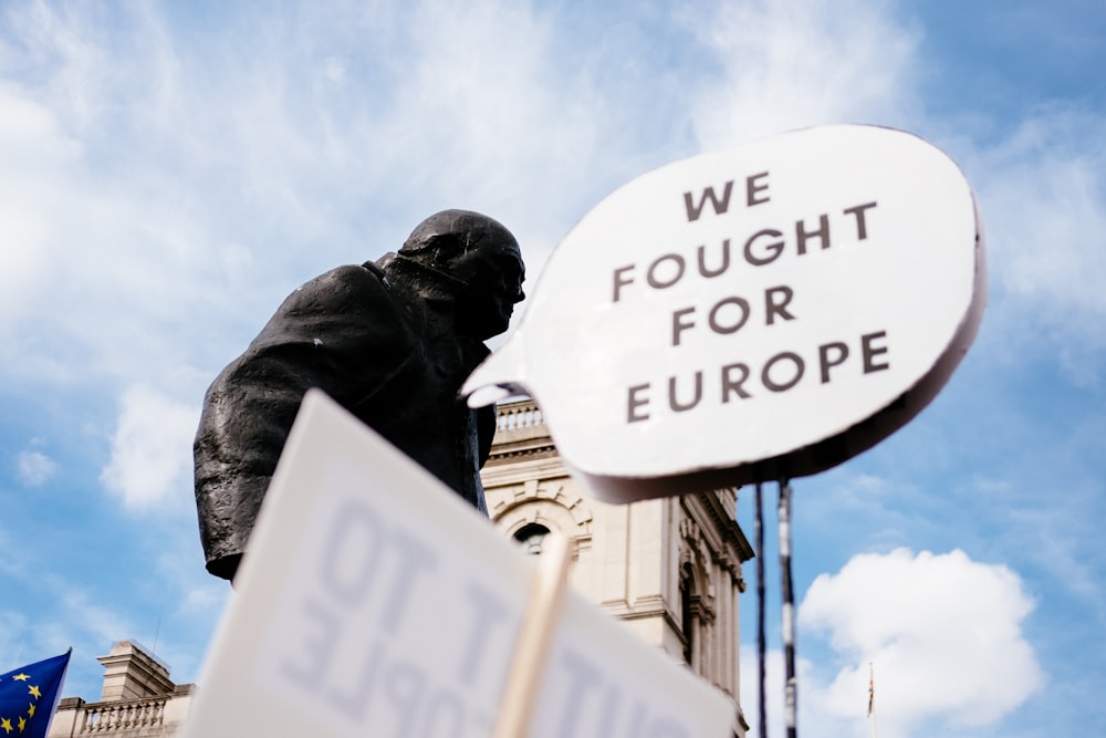 a statue of a man holding a sign that says we fought for europe