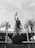 A prominent statue of a figure holding a trophy stands atop a large globe-like base inscribed with 'BRASIL 1958 1962'. The statue is surrounded by tall palm trees, and in the background, there's a large circular building with columns.
