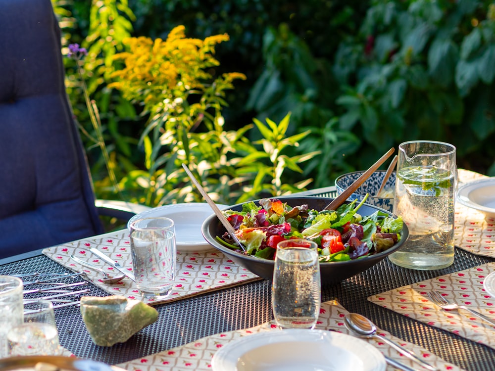 a bowl of salad sitting on top of a table