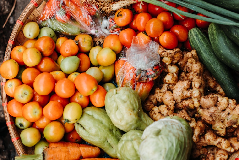 red and orange tomatoes near chayote and cucumbers