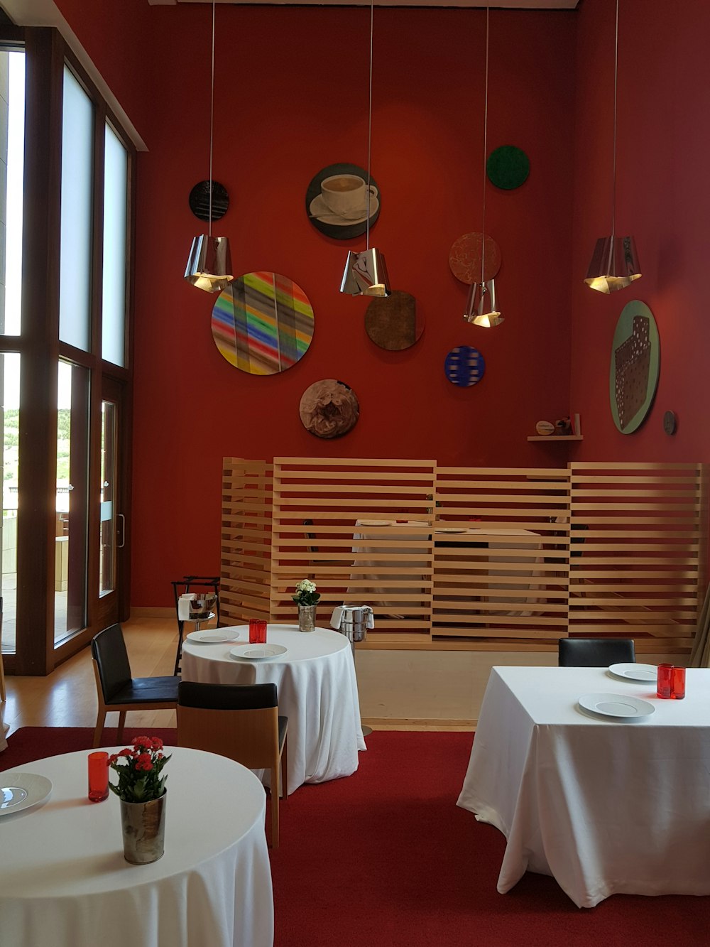a restaurant with a red wall and white tablecloths