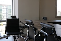 five black rolling chars front of desk