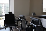 five black rolling chars front of desk
