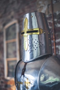 Close-up of a legionnaire’s helmet with amber glows reflecting a distant battle.