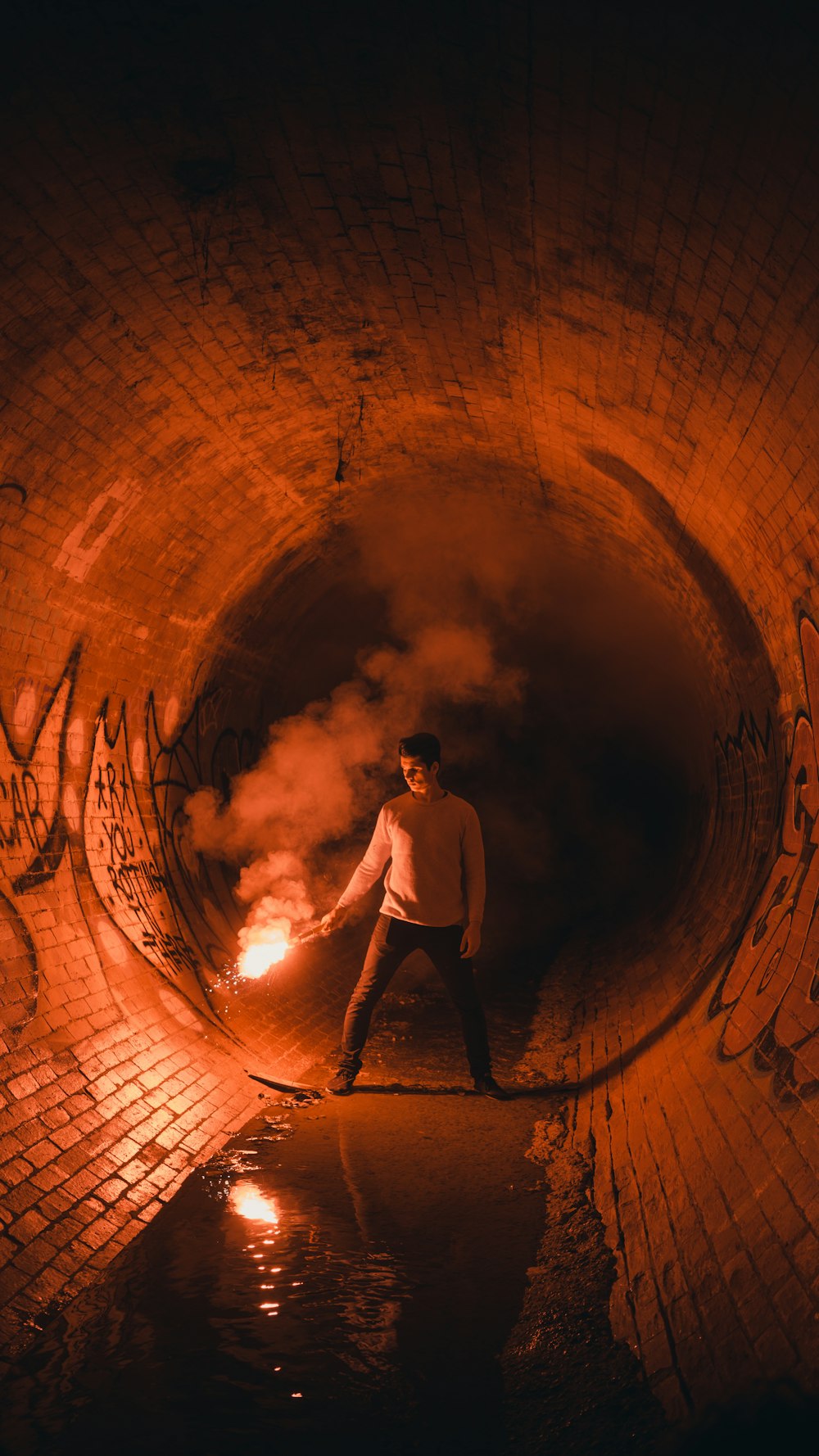 standing man holding torch in tunnel