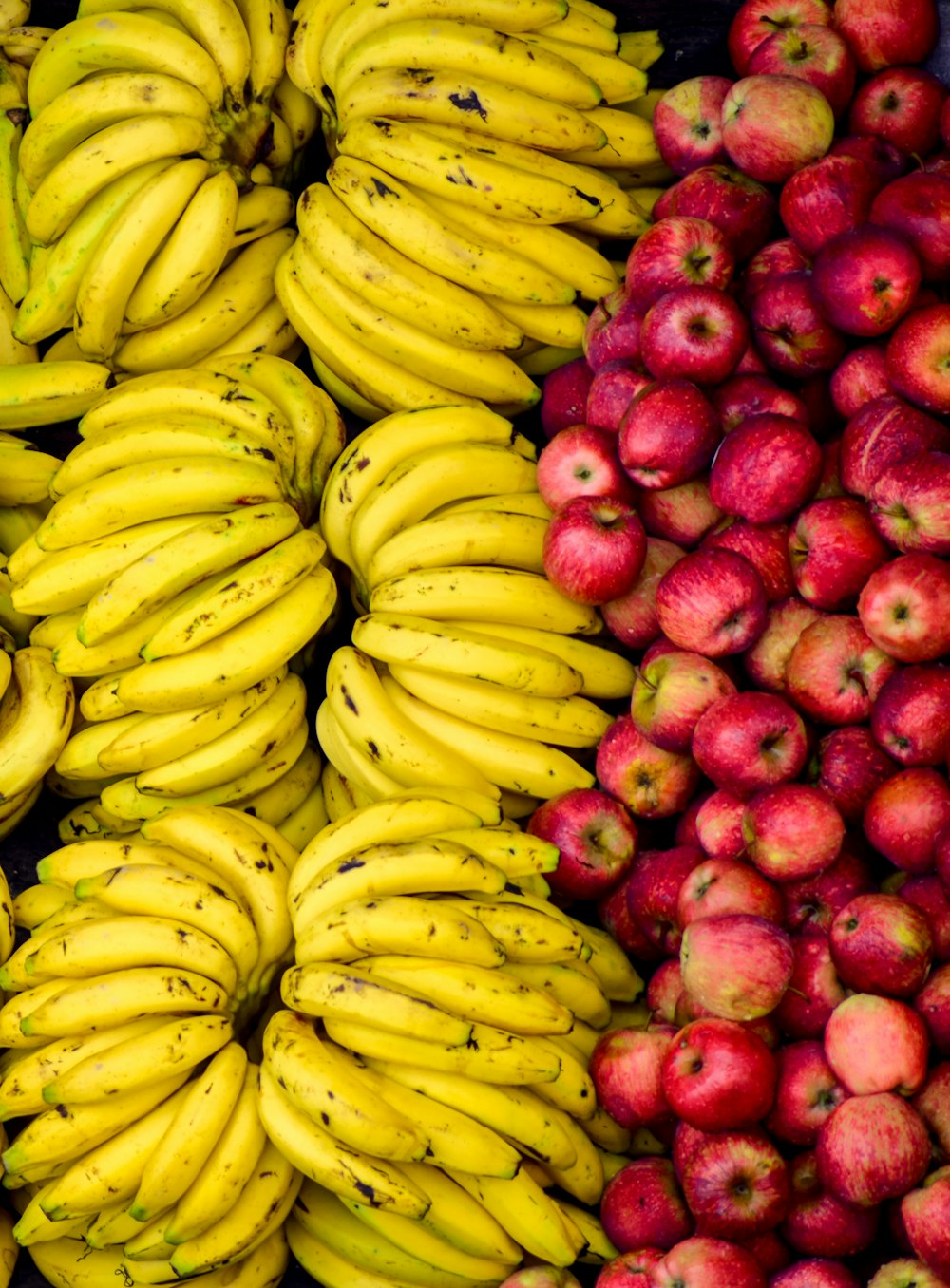 a bunch of bananas sitting next to apples