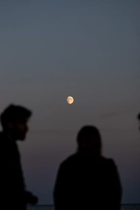moon in the background of a man and a woman