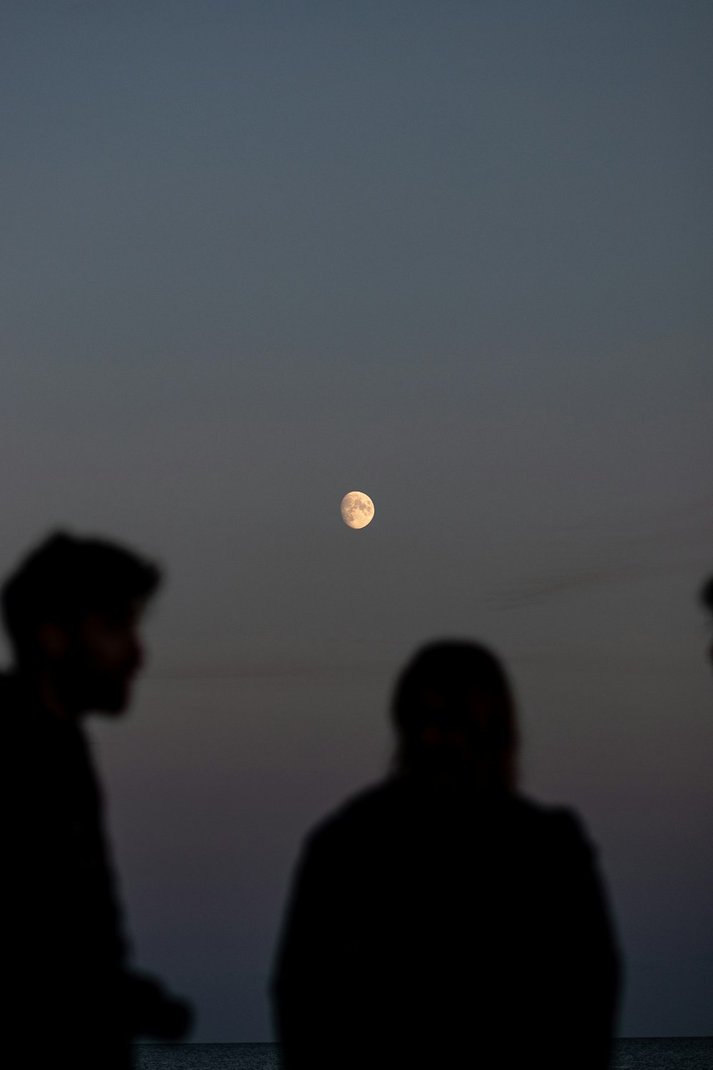 moon in the background of a man and a woman