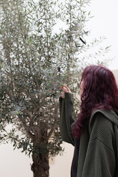 Technician examining oil palm leaves for nutrient health.