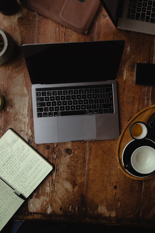 A cozy desk with a laptop, a cup of tea, and a notebook, inviting conversation.