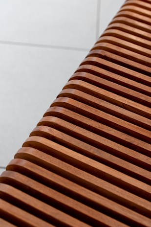 Wide view of a modern wooden bench placed in a bright studio.