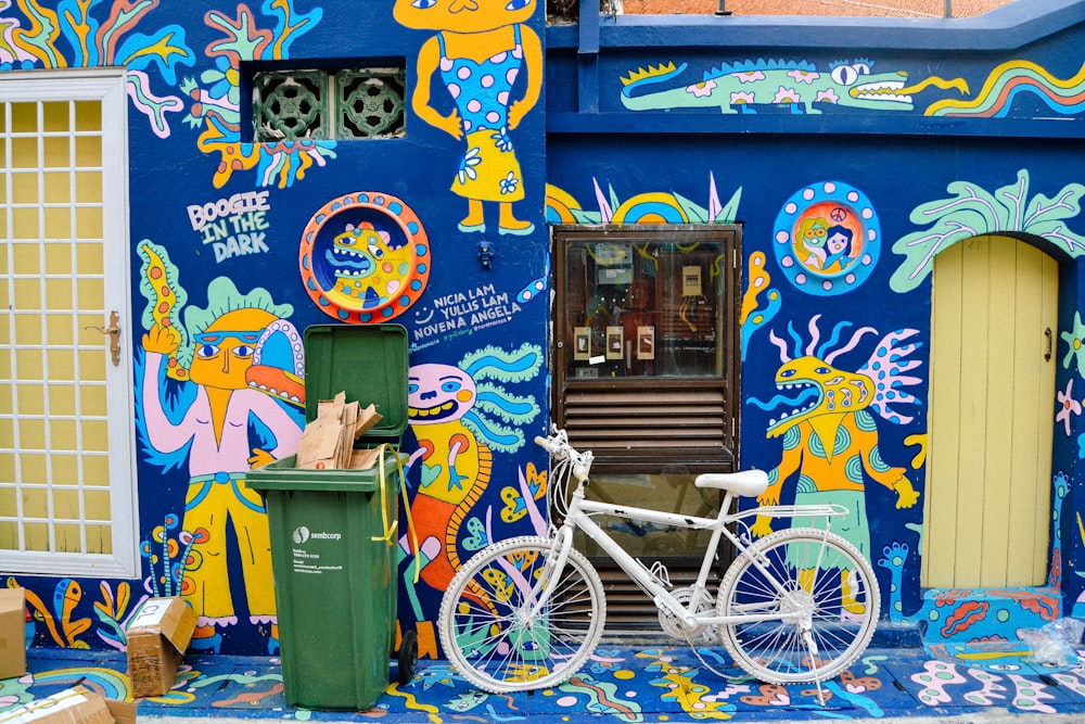 parked white mountain bike near blue and multicolored concrete wall