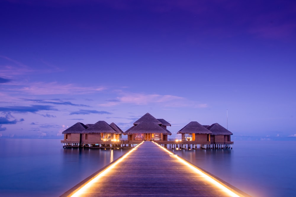 brown boardwalk to houses on sea