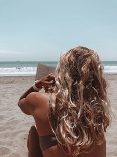 woman in brown bikini holding book