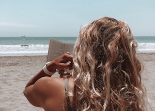 woman in brown bikini holding book