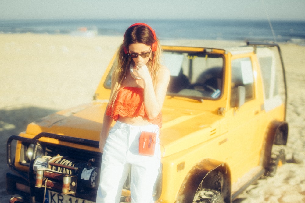 woman standing near yellow vehicle