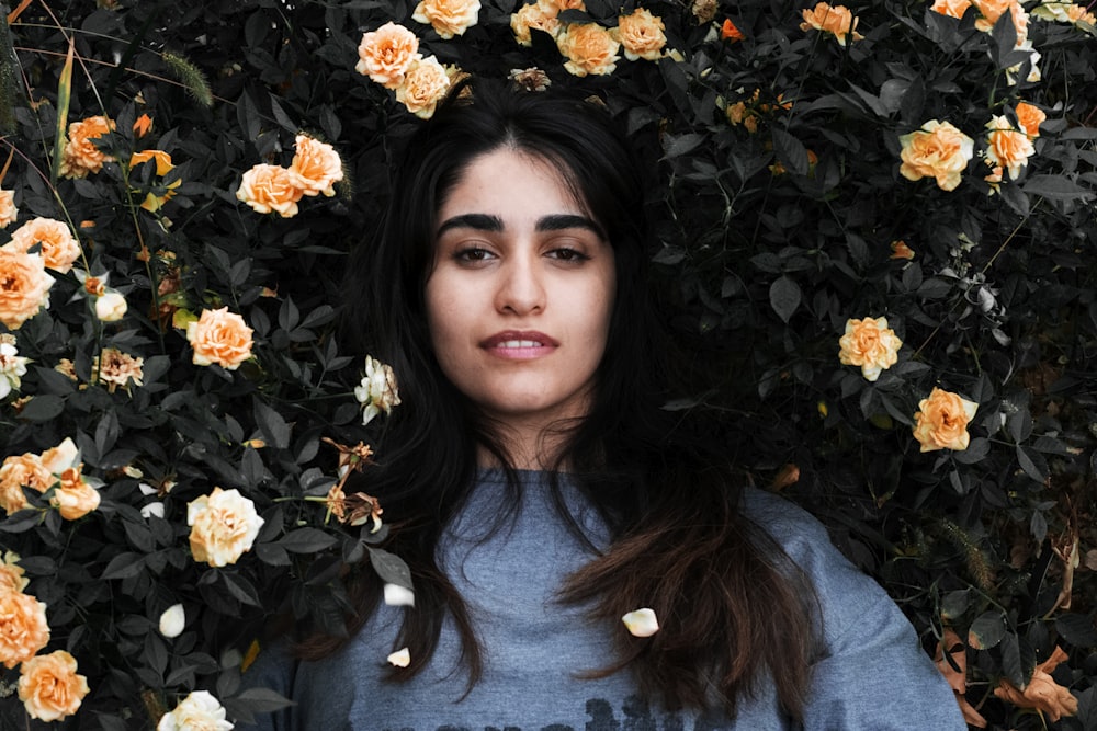 woman lying beside white rose flower plant