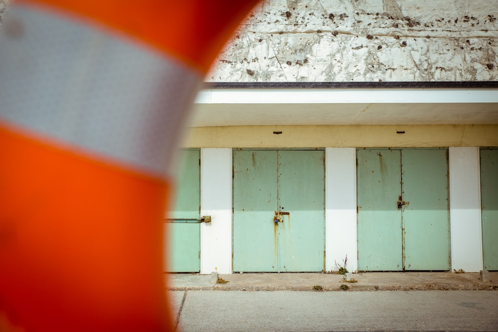 an orange and white traffic cone sitting in front of a building