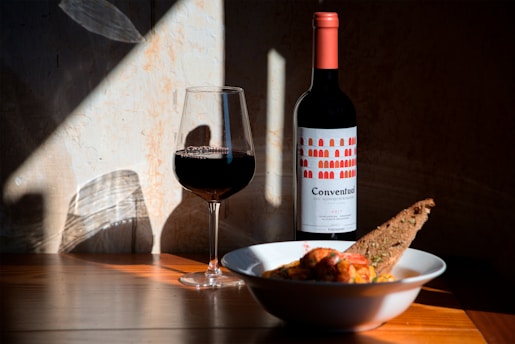 bowl of food beside wine glass