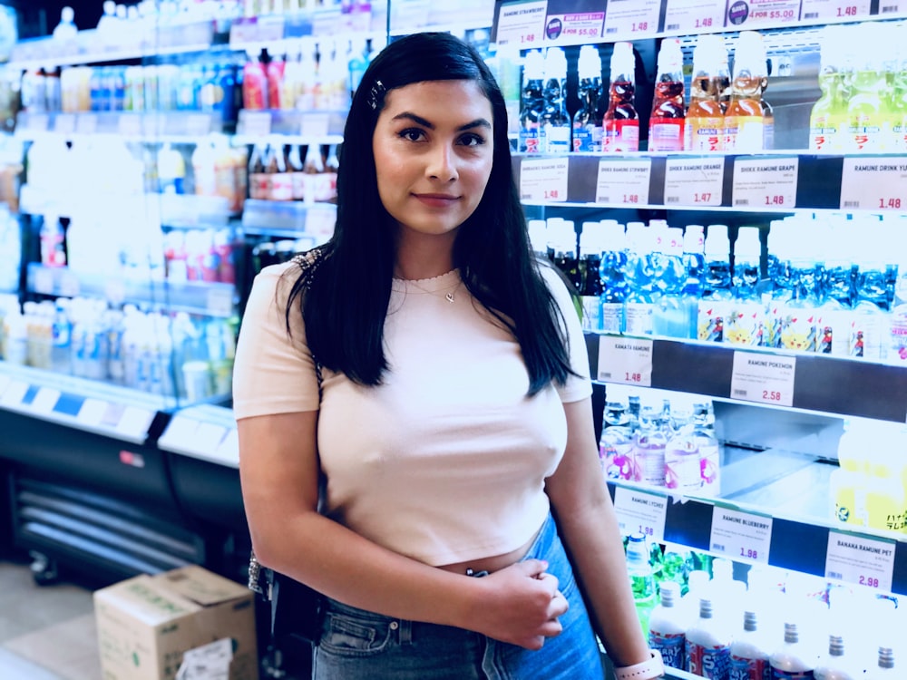 woman standing beside beverage displat