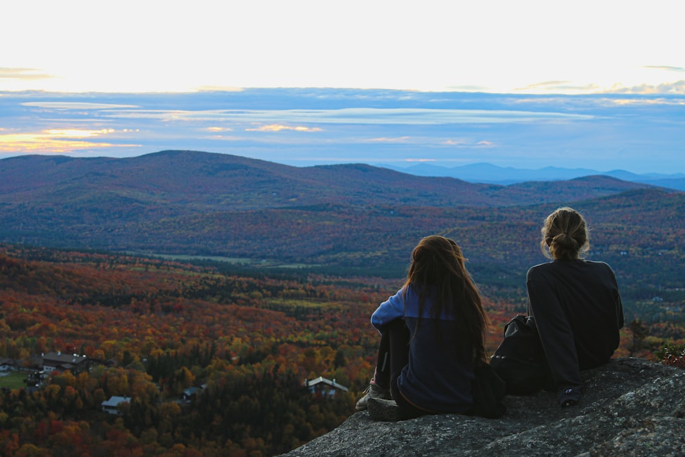 two women sitting on rocks