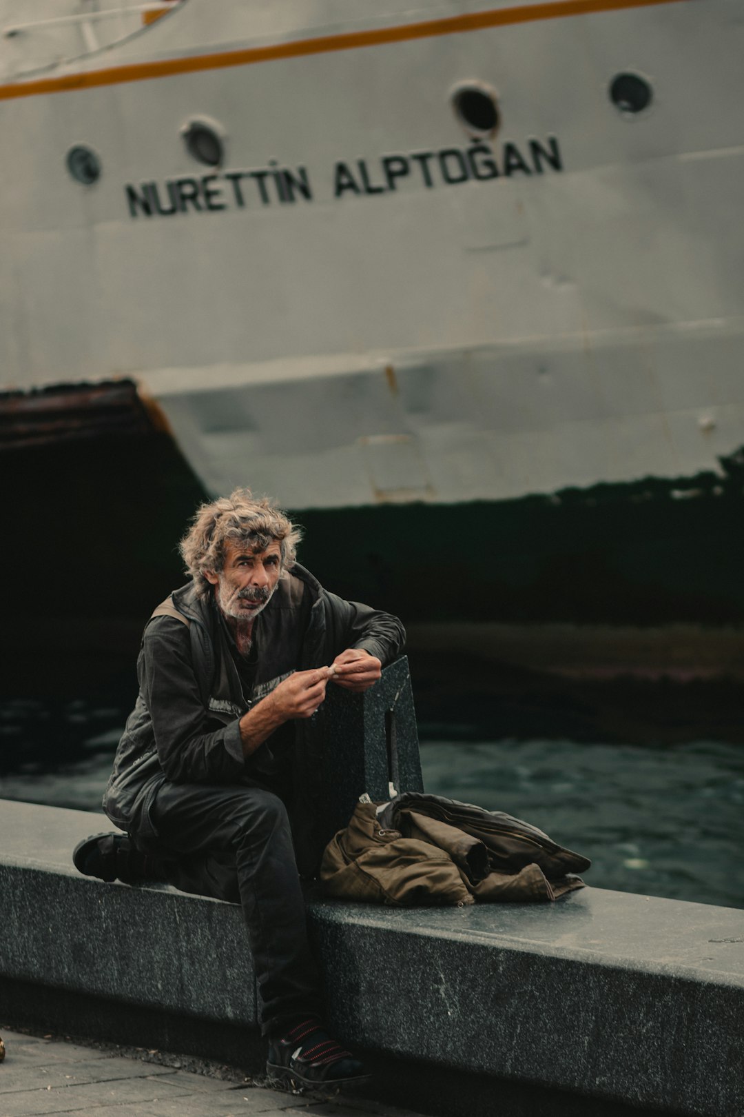 man sitting near sailing ship