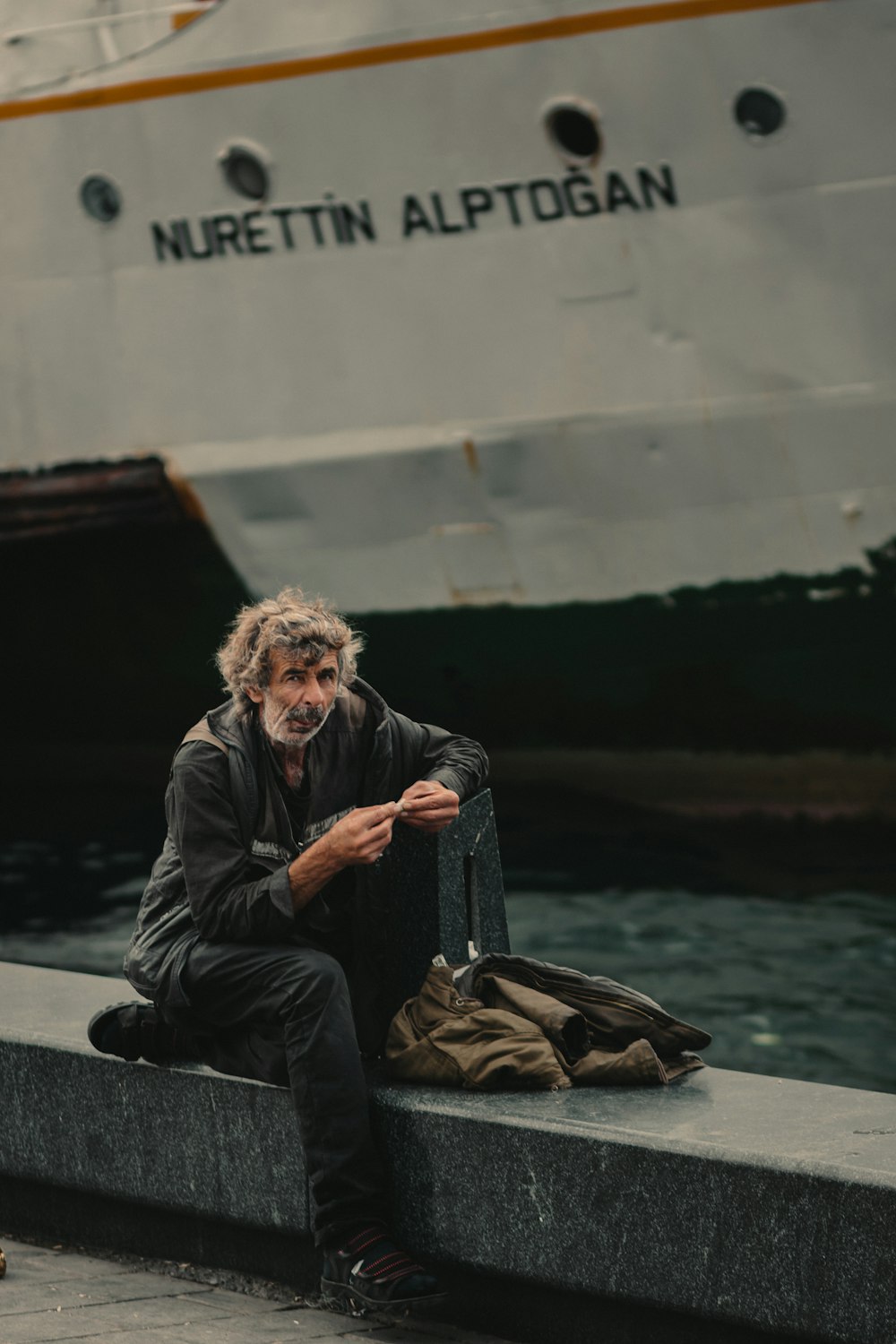 man sitting near sailing ship