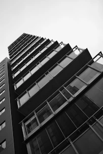 Black and white photo of a modern apartment building with soft shadows highlighting its geometric lines.