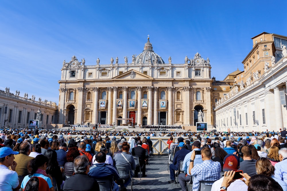 crowd of people sitting in front of a cathedral