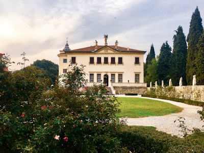 A historic villa surrounded by mature trees and manicured gardens.