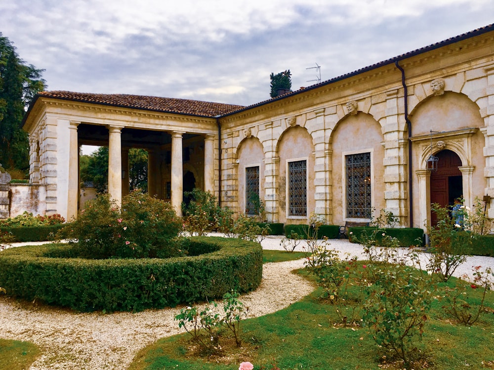 green garden and white stone house