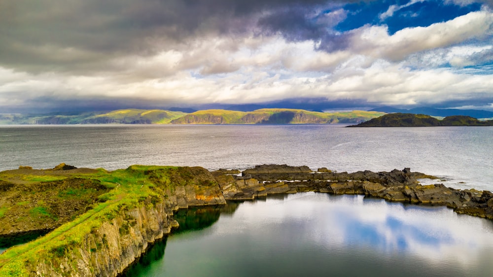 body of water by mountains during daytime