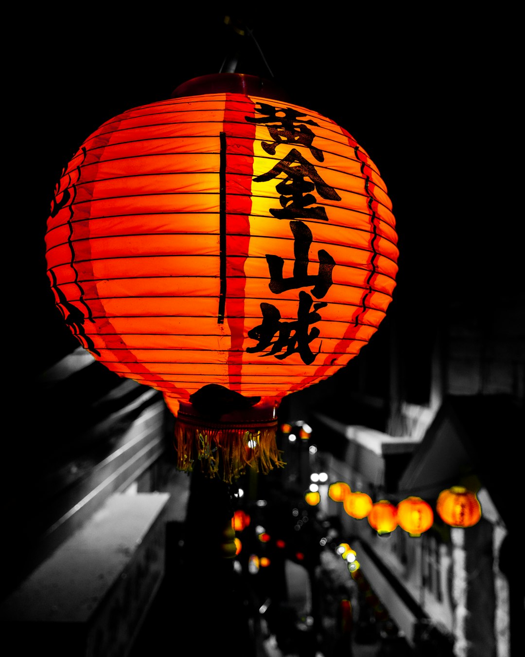 lighted orange and black paper Chinese lamps during night time