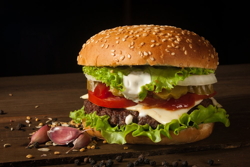 hamburger with vegetables on wooden surface