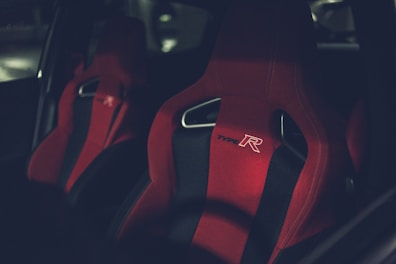 Close-up of a racing simulator seat with ergonomic design and branded stitching.